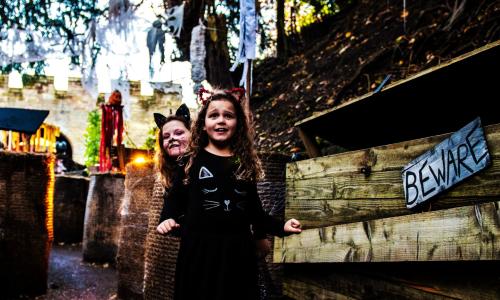 Two children in Halloween fancy dress smiling and enjoying Warwick Castle