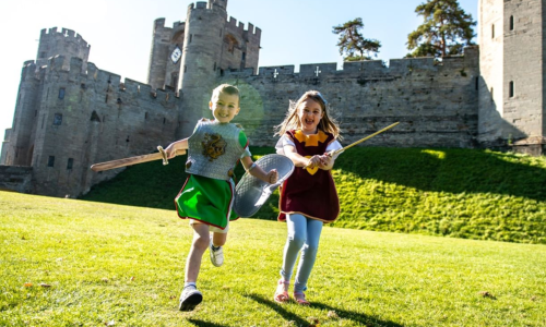Two children at Warwick Castle holding swords