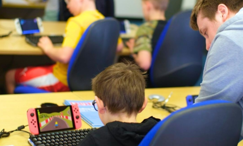 A boy playing watching a game on a Nintendo