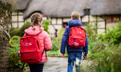A girl and a boy wearing red backpacks at Anne Hathaway's Cottage