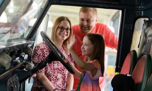 A family having fun in a vehicle at the British Motor Museum