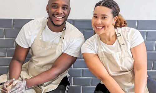 A couple working at neighbouring pottery wheels
