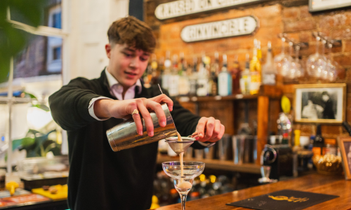 A boy pouring a cocktail