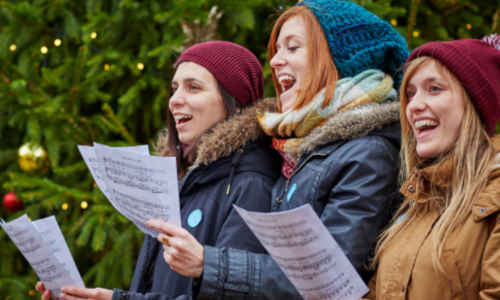 Three women singing carols