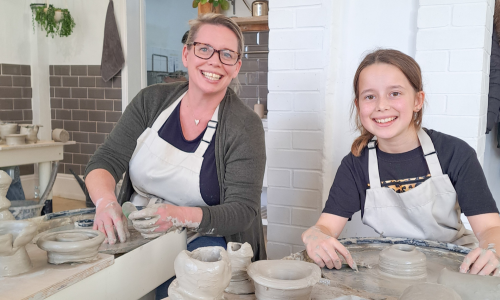 A mother and daughter pottery making together