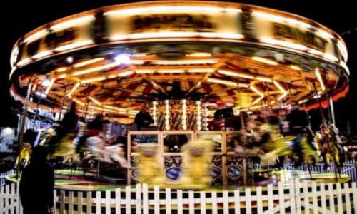 A merry go round spinning around at an evening fun fair