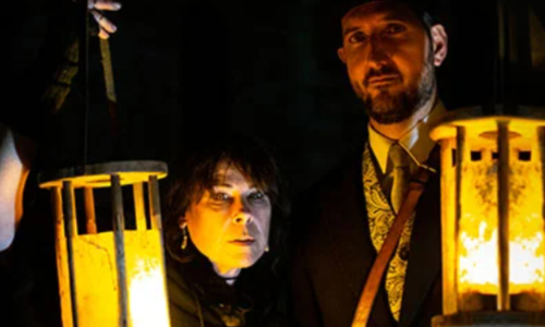 A woman and a man holding lanterns