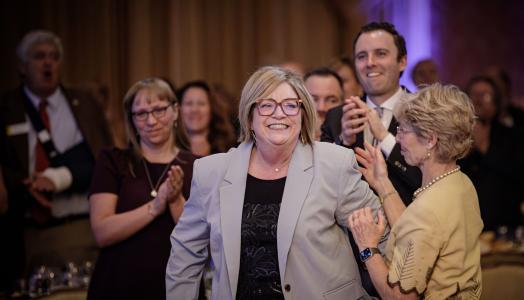 WOT Executive Director makes her way to the stage to accept the 2025 Big WYO Award during the annual Wyoming Governor's Hospitality & Tourism Convention at Little America Resort & Hotel in Cheyenne.