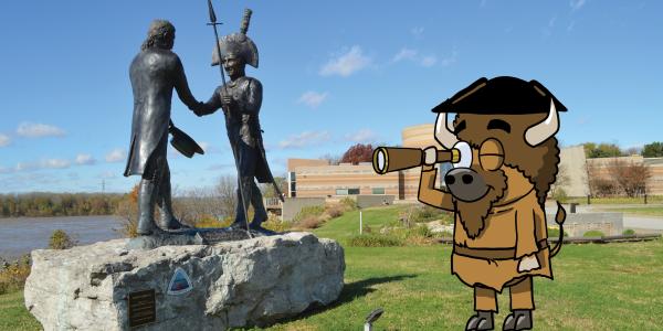 Cartoon Billie the Bison dressed as an explorer looks through a spyglass beside the Lewis and Clark Handshake Statue overlooking the Ohio River at Falls of the Ohio State Park.