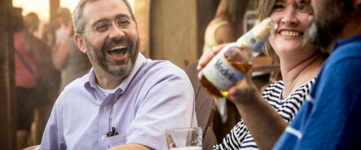 A group of friends laughs over a beer at Pour Haus in New Braunfels.