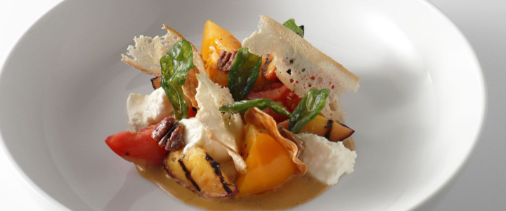 A colorful serving of burrata cheese displayed on a white dish
