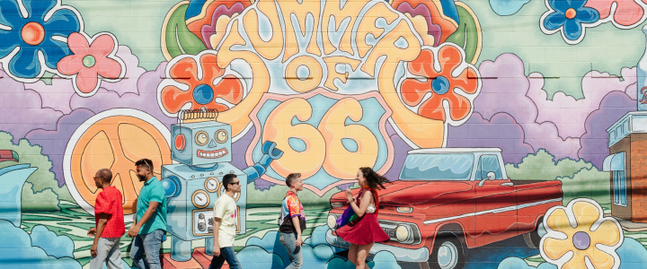 Group of people walking in front of a 39th Street Mural
