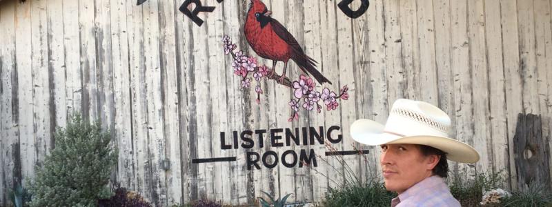 Man sitting on bench outside of the Redbird Listening Room