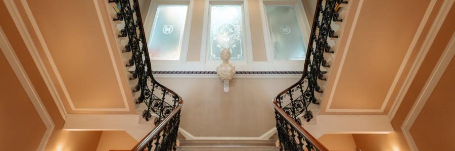 Inside the Hull Maritime Museum. Looking upwards towards the stairs balcony with a statue bust in the centre.