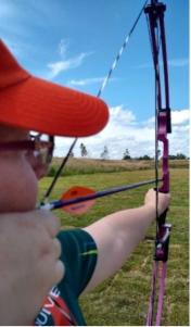 A person aiming their bow and arrow