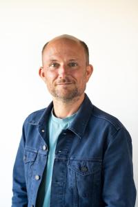 Headshot of Tom Stroud smiling at the camera