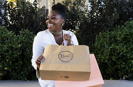 Young Black woman sitting with two shopping bags
