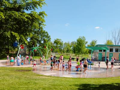 Splash Pad on a warm, sunny day with kids playing in the outdoor water structures.