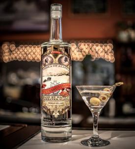 A bottle of Hoarfrost Distilling vodka and a martini with olives.