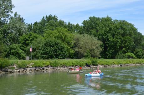 Kyakers wave to tour boats on the Erie Canal in Rochester, NY
