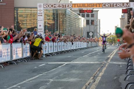 racers cross the finish line in the Rochester Criterium