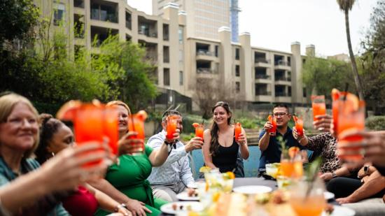 People toasting orange drinks on a river barge