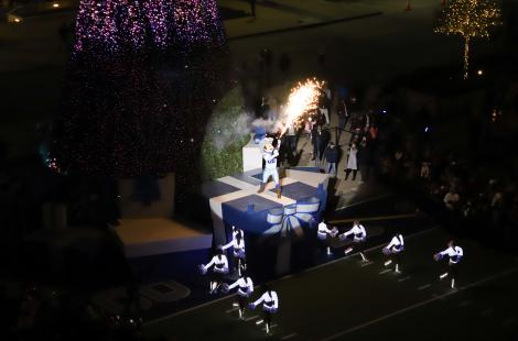 Dallas Cowboys mascot with a firework torch on top of blue presents