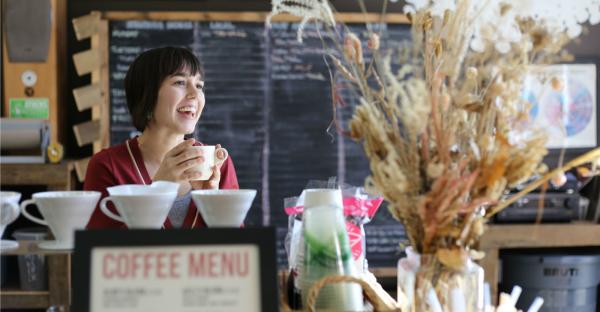 Smiling local enjoys coffee at a local coffee shop in Athens, GA.