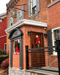 Picture of the front entrance at Axemann Tavern with Holiday greenery and big red bows decorating the tavern for the holidays!