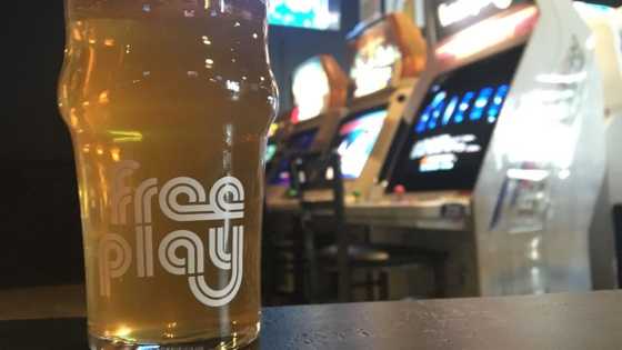Photo of beer in front of arcade games at Free Play Arlington