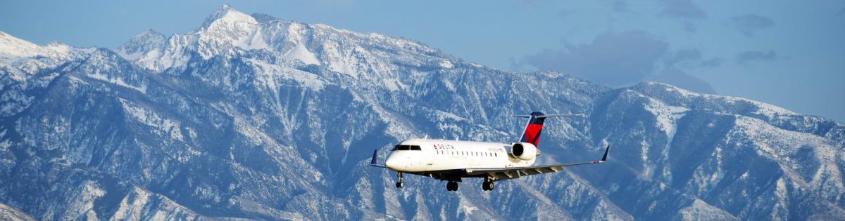 Delta Airplane coming into landing in Salt Lake City with the Wasatch Mountains in the background