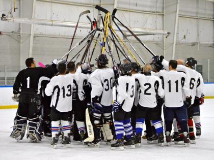 hockey players raise sticks in the air at the Rochester Bill Gray's Ice Plex