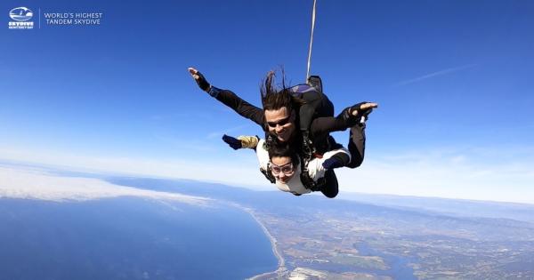 This is an image of two people tandem sky diving over Monterey Bay