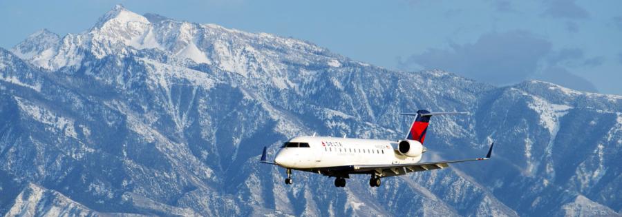 Delta Airplane coming into landing in Salt Lake City with the Wasatch Mountains in the background