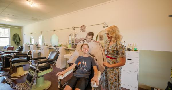A child sits in the Elvis chair at the Chaffee Barbershop Museum, Fort Smith, Arkansas.