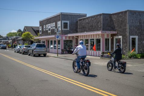 People riding fat tire bikes on Hemlock Street past Bruce's Candy Kitchen in Downtown Cannon Beach