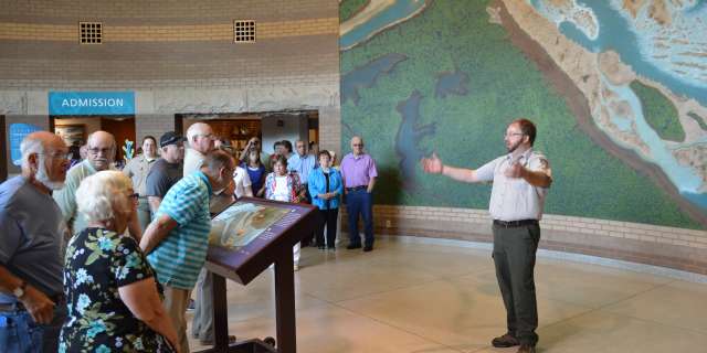 A group listens to information at the Falls of the Ohio State Park