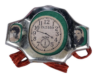 Toy watch with images of Elizabeth Taylor and Gregory Peck on either side of clock image.