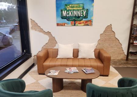 two green chairs and brown couch with Visit McKinney sign