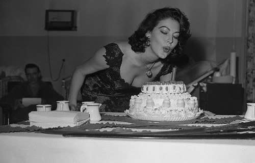 Ava Gardner blowing out a candle on a cake