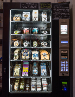 Vending machine stocked with cheeses, snacks, and small jars.