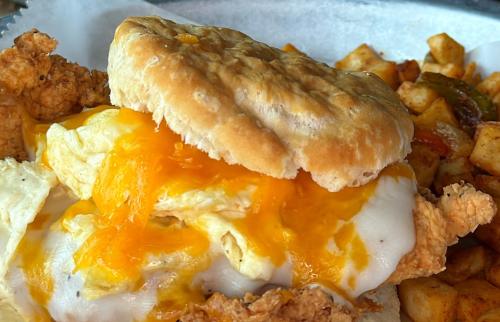 biscuit sandwich with friend chicken, egg, cheese and cottage fries
