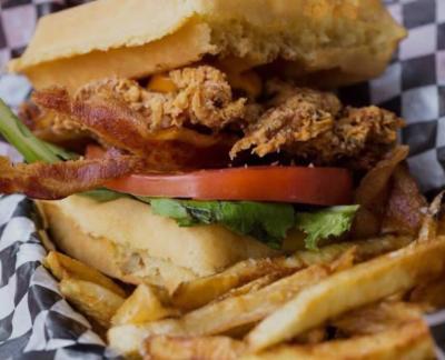 Waffle sandwich with chicken, lettuce, tomato, and french fries