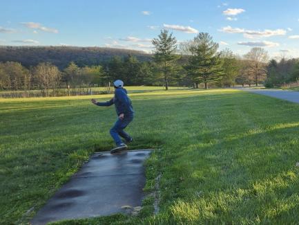 A man tees off on Canoe Creek State Park's disc golf course