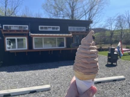 hand holding a soft serve chocolate ice cream cone outside of Brackenridge Hesston