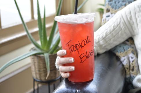 a hand holding a Tropical Blast loaded drink from Lake Rays' Nutrition