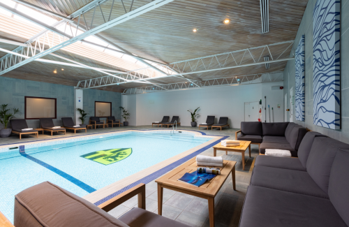 clear blue empty swimming pool with loungers around the edge