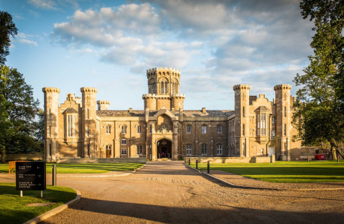 The grand front entrance to Studley castle hotel on a sunny day taken from the tree lined driveway