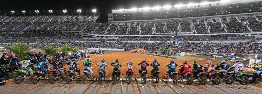 A line of motorcycle supercross racers is ready to compete under the lights at the World Center of Racing, Daytona International Speedway