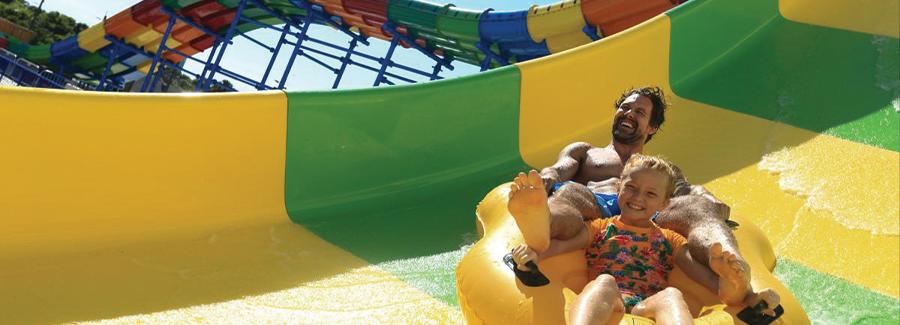 A father and daughter enjoy a fun water slide at Daytona Lagoon